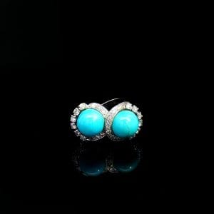 Platynowy pierścionek z turkusami otoczonymi diamentami – intrygująca forma, kunszt detalu